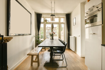 a kitchen and dining area in a house with white walls, wood flooring and black curtains on the windows