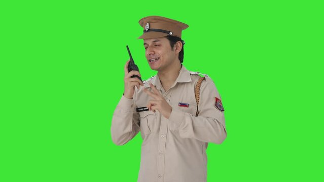 Happy Indian Police Officer Giving Instructions On Walkie Talkie Green Screen