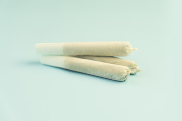 Preparing a cannabis joint with tobacco and rolling paper with marijuana bud on blue background. The insinuation of marijuana abuse. cannabis legalization concept.