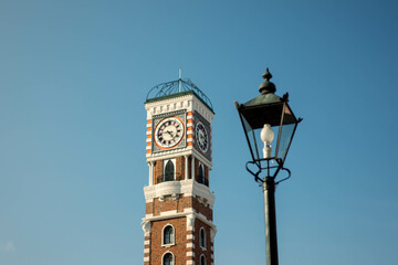 Fototapeta na wymiar Brick Clock Tower with Classic Street Lamp