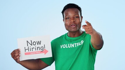 Volunteer, recruitment and face of black man with hand pointing at you in studio on blue background. Charity, donation and portrait of African male activist with ngo, poster or community service sign