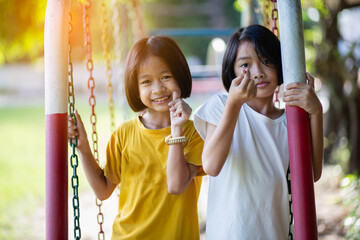 Two cute little girls having fun on a playground outdoors