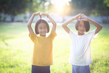 Obraz premium Adorable little siblings play happily on the green grass.