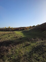 A grassy hill with a hill in the background