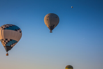 Hot air balloons take off from the ground early in the morning. Hot air balloons flying over bizarre rock landscape in Cappadocia. Beautiful hot air balloons in the morning sky. Goreme. Turkey