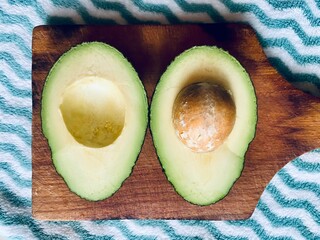 Avocado. Avocado cut in half with pit. Avocado oil.