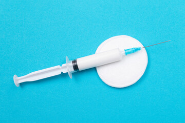 Vaccination, Immunology or Revaccination Concept - A Medical Syringe Lying on Blue Table in...