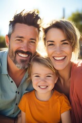 Obraz premium Family photo of a married couple with their daughter. Smiling faces. Happy family. Photo with sunshine and laughing people.