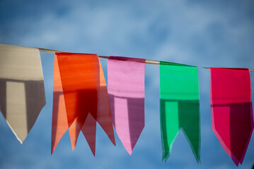 Festive decoration flags of different colors hanging with string.