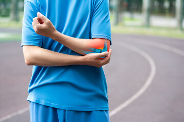 Diseases of the elbow joint, bone fracture and inflammation, athletic man on a running track after...