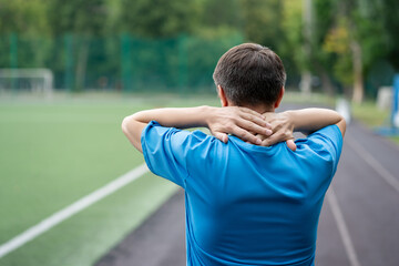Neck pain, athletic man with backache on a running track after workout