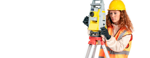 Construction site engineer woman in safety equipment working with surveying total station EDM...