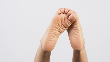 Male soles of feet and Cross his feet is isolated on white background