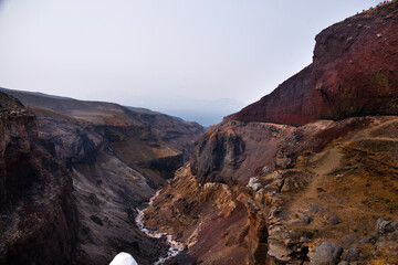 Beautiful landscape of Kamchatka Peninsula: view of Dangerous Canyon , picturesque waterfall on the river Vulkannaya under the active Mutnovsky Volcano.