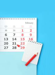 Calendar of 29 february date, notebook and pencil on blue Background. February month calendar. Leap...