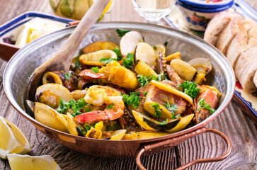 Traditional Portuguese seafood cataplana with king prawns, vongole clam and squid in white wine...