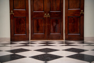 Wooden doors at the end of hall with black and white tails