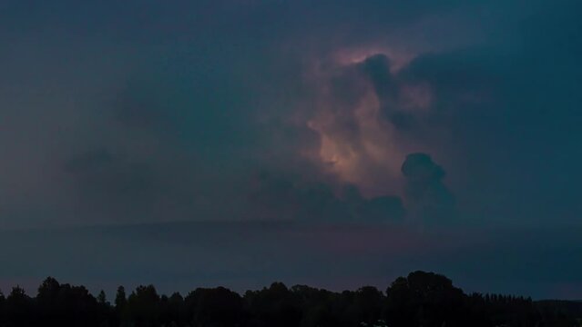 Timelapse of a heavy lightning storm flashing and rolling over evening darkness