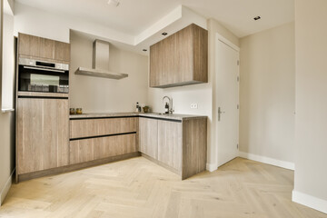 a modern kitchen with wood flooring and white walls in the room is very clean, ready for guests to use