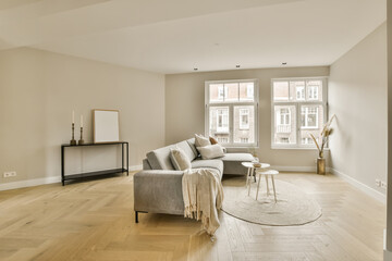 a living room with hardwood flooring and white walls in the center of the room is a large window...