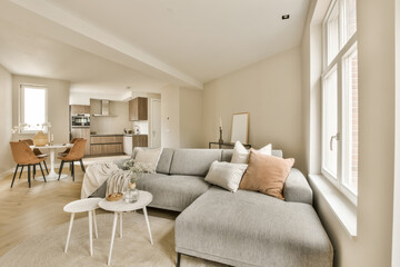 a living room with couch, coffee table and kitchen in the photo is taken from the front window looking into the dining area
