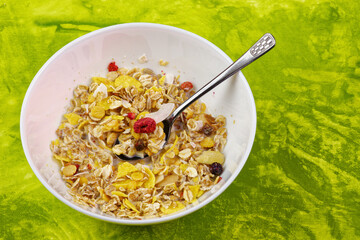 Musli in bowl on green background