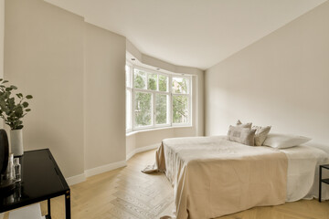 a bedroom with white walls and hardwood flooring in the room, there is a large window that looks out into the garden