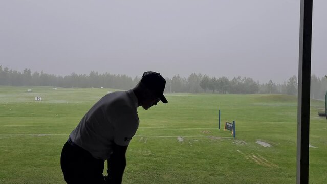 Pro golf is practicing at golf driving range. Sports man plays golf and hit ball on golf course
