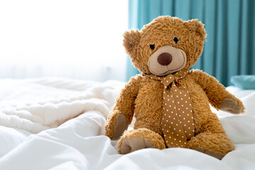 Teddy bear toy sitting on bed empty copy space. Maternity concept.Childhood.
