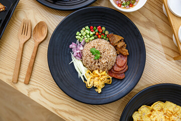 Fried rice mixed with shrimp paste with marinated pork, herb and vegetable is Thai traditional food