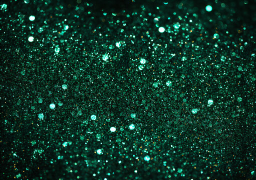 Glitter in different shades of green reflecting light to create a sparkling effect.