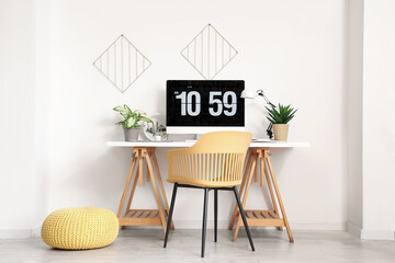 Modern workplace with computer monitor and artificial plants in light office