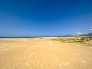 long sandy beach and dunes in Tarifa with a view towards the dune of Valdevaqueros at a beautiful...