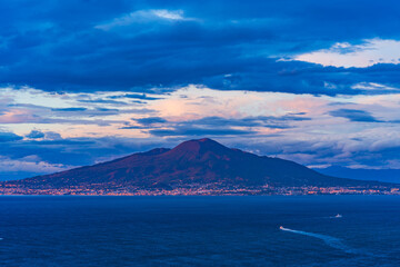 View of Mount Vesuvius across the Bay of Naples in Italy at dusk
