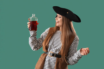 Beautiful female pirate with rum on green background