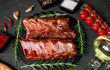 raw marinated pork ribs with spices on stone background with a copy of the space for your text