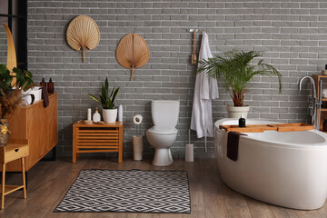 Interior of modern bathroom with bathtub and toilet bowl
