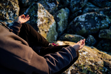 Man meditating in lotus position top view, hands on knees in chinmudra, yoga asana, meditation in the mountains, ashtanga yoga, zen.