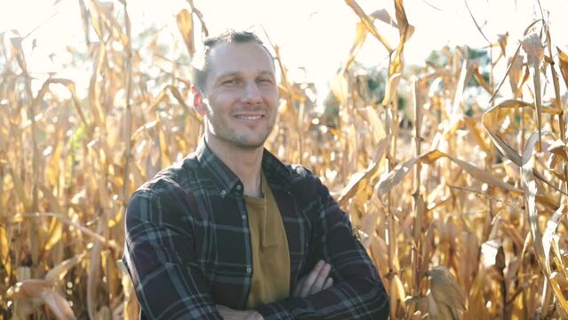 Portrait of caucasian male farmer folding his hands in front of him in corn field. Calm look of satisfied entrepreneur growing food in large areas. Dry period in agriculture.