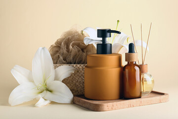Bottles of cosmetic products, spa accessories and lily flowers on color background