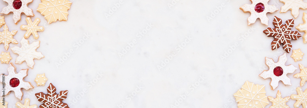 Poster Christmas baking double border with an assortment of snowflake cookies. Overhead view on a white marble banner background with copy space. Holiday baking concept.