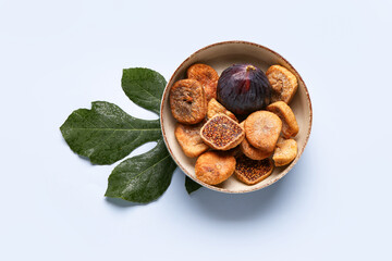 Bowl with sweet dried figs and fresh fruit on blue background