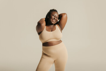 Joyful African plus size woman in underwear radiating love to her body on studio background