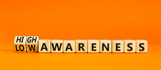 High or low awareness symbol. Concept words High awareness Low awareness on wooden blocks. Beautiful orange table orange background. Business High or low awareness concept. Copy space.