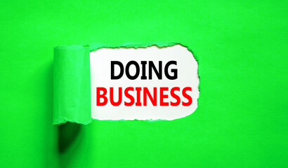 Doing business symbol. Concept words Doing business on beautiful white paper. Beautiful green table green background. Business, motivational Doing business concept. Copy space.