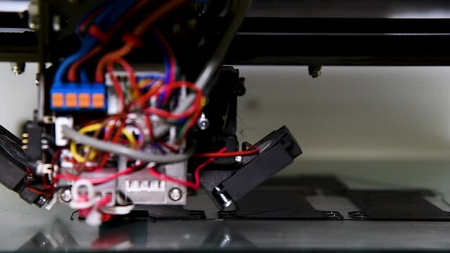 3D printer close-up printing the product. The printer elements are moving