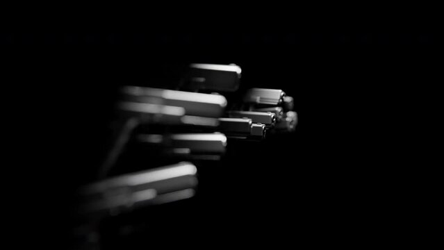Side view of many Handguns coming out of the darkness