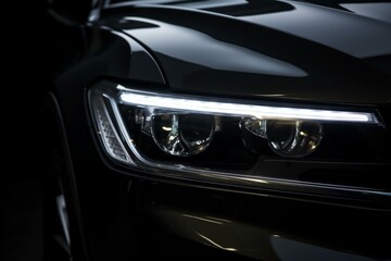 Obraz na płótnie Canvas Close-up of a modern car's LED headlight on a black background. Generative AI