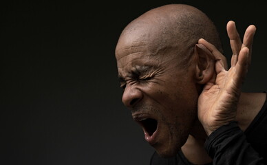 deaf man suffering from deafness and hearing loss on grey background with people stock photo	