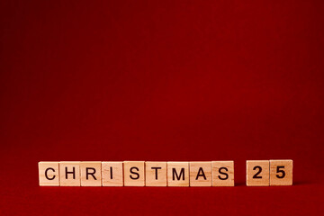 the word Christmas composed of wooden letters on a red background